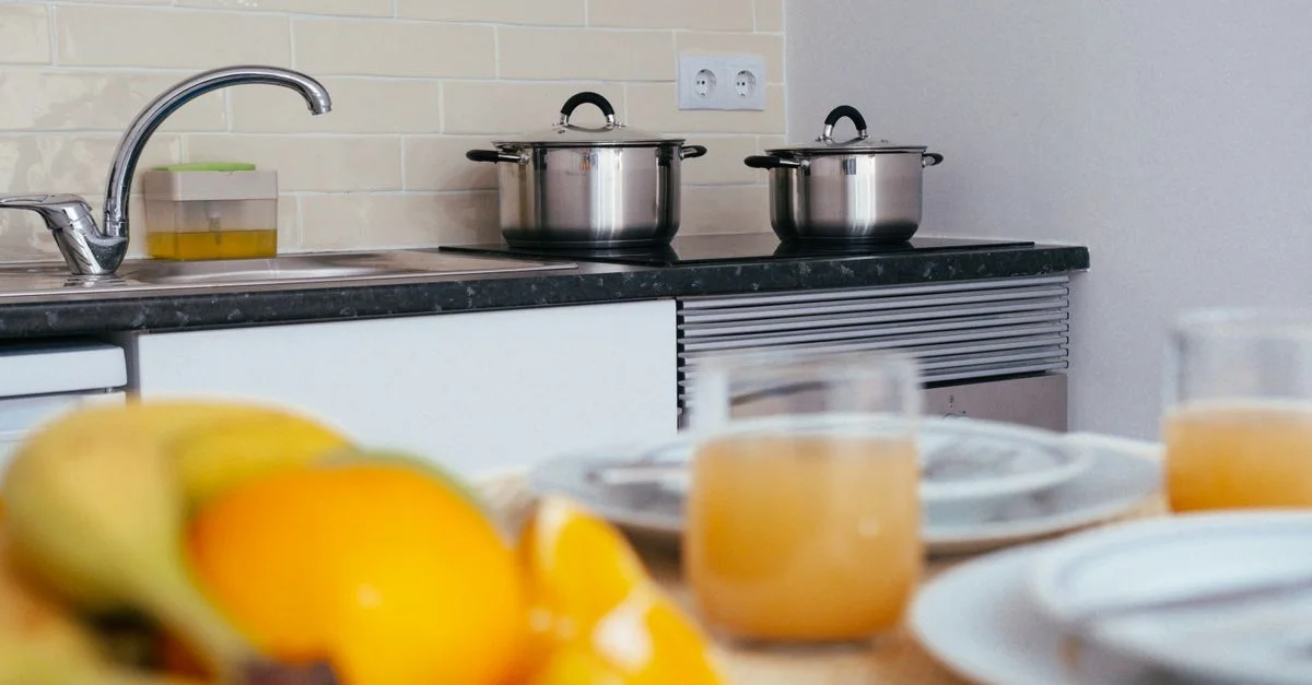 Espace cuisine contemporain avec des fruits frais et du jus d'orange sur une table.
