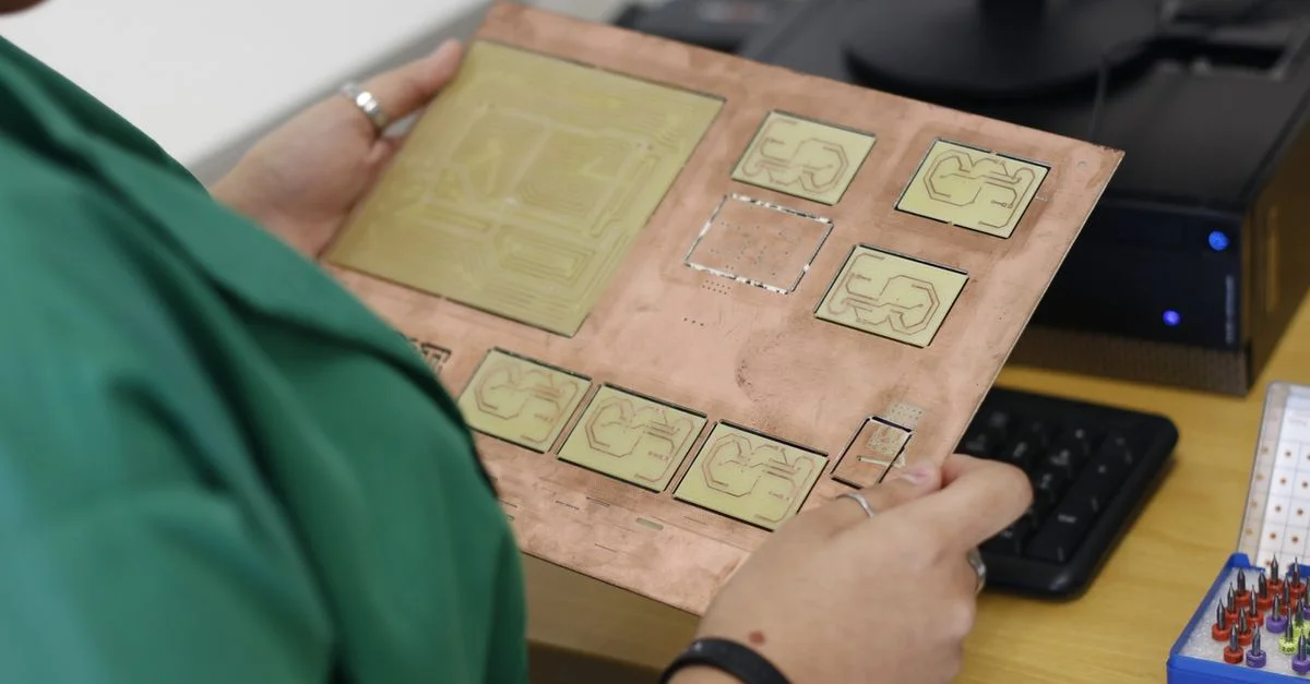 Un technicien examine un circuit imprimé dans un laboratoire d'électronique moderne.