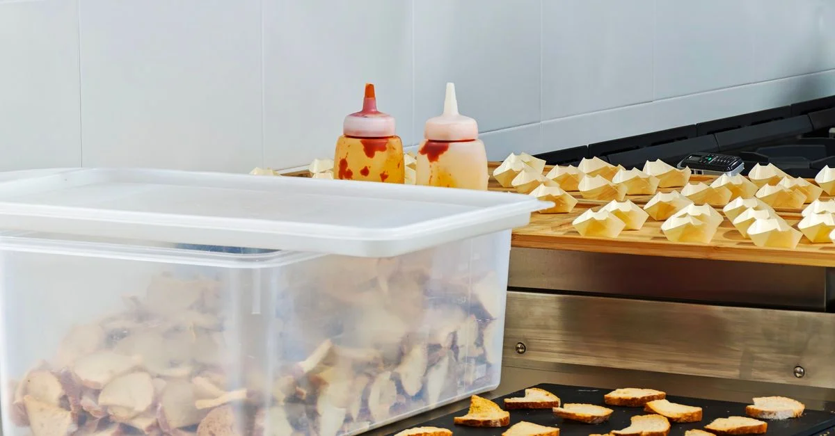 Des tranches de pain soigneusement disposées avec des sauces dans une cuisine professionnelle.