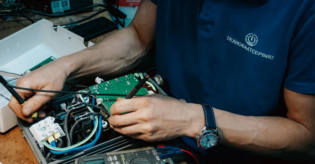 Un technicien répare méthodiquement une carte de circuit imprimé, faisant preuve d'expertise en électronique et de compétences techniques.