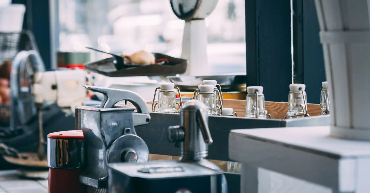 Gros plan sur un plan de travail de cuisine avec des appareils et des bouteilles en verre à l'intérieur.