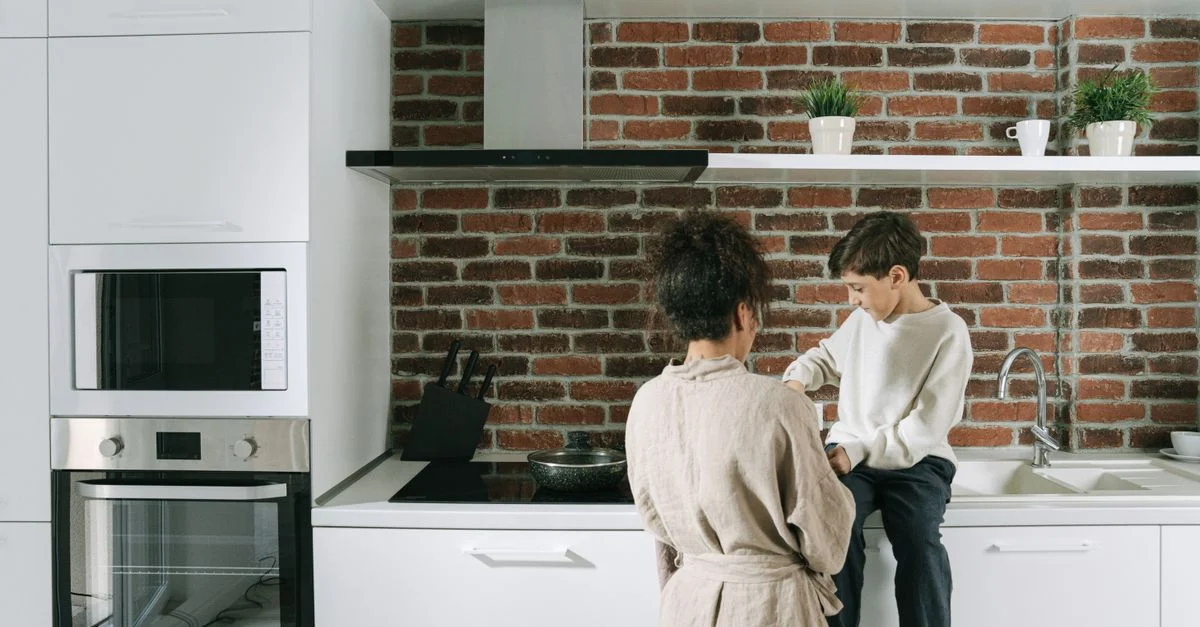 Une mère et son fils se liant dans une cuisine moderne et confortable avec un mur en briques.