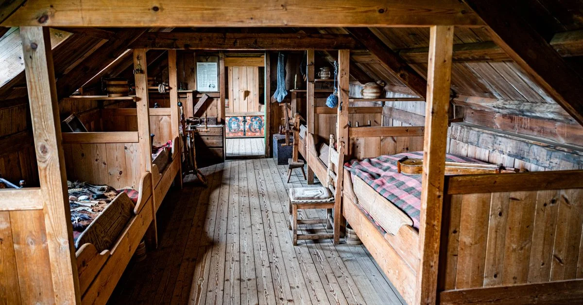 Chambre de grenier rustique et confortable avec des meubles en bois et une décoration chaleureuse.
